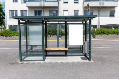 Şehir caddesindeki otobüs durağında iki tane dikey beyaz ilan panosu var. Arka plandaki binalarda ve yolda. Model yap. Güneşli yaz gününde poster.