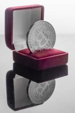 Alyans kutusundaki bitcoin. Madencilik ve kripto para ile hayatınızı değiştirin. Ayna yüzeyine yakın plan, açık arkaplan..