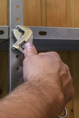 El işi, ingiliz anahtarı ile çalışmak, bir çilingir rafları toplar ya da söker.