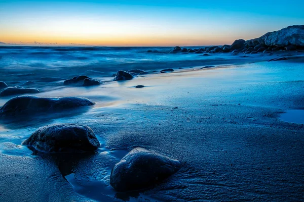 발트해의 해안에 돌멩이들 입니다 태양을 배경으로 아름다운 일몰과 색깔의 스타일로 — 스톡 사진