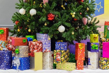 Noel ve yeni yıl tatillerinde, çok sayıda hediye çok renkli bir ambalaj kağıdıyla ağaçta güzel oyuncaklarla büyük bir Noel ağacının altında..