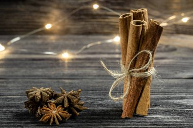 Kapalı bir demet tarçın ve ahşap arka planda yıldız anason bileşimi. Yumuşak şarap için tatil baharatları.