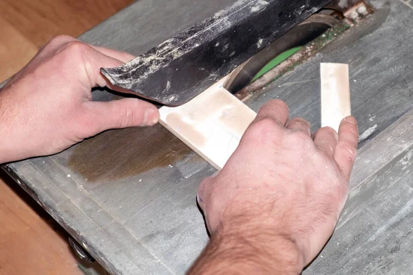 the process of cutting tile on a special tool with a diamond disk and wet sawing without dust. repair work performed by a specialist with a modern tool.