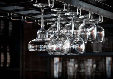 Bir kokteyl, viski ve konyak bardakları kafelerde baş aşağı duruyor, restoranların içleri uzatılmış cam ve yuvarlak bardaklarla dolu. Bir barın arka planında alkol şişeleri vardı..