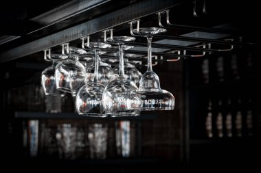 Bir kokteyl, viski ve konyak bardakları kafelerde baş aşağı duruyor, restoranların içleri uzatılmış cam ve yuvarlak bardaklarla dolu. Bir barın arka planında alkol şişeleri vardı..