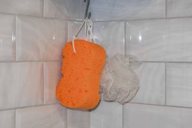 dikdörtgen turuncu plastik ve yuvarlak çevre dostu beyaz bez banyoda bir kancaya asılı fayans zemin