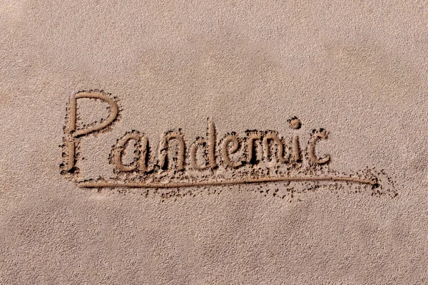 Pandemic concept on planet earth. following and traveling viruses and diseases to the most remote places on the planet. MERS-Cove. 2019-nCoV. Text Pandemic on a sandy beach, background made of sand, flat.