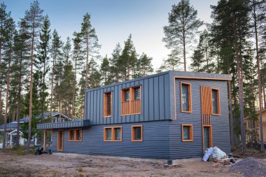 Çam koruluğunda inşa halinde modern bir ev. Şehir dışında inşaat, doğada, büyülü bir ormanda özel bir bölge..