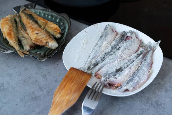 고기는 밀가루를 접시에서 냄새를 그릇에 튀기고 남비에 튀기는데 과정에서 생선을 — 스톡 사진