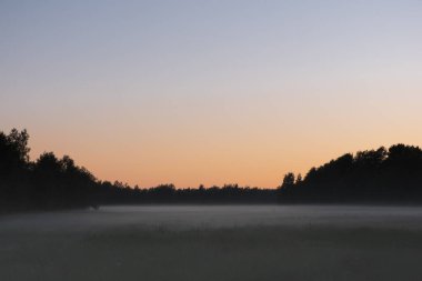 Gün batımında sahanın üzerinde az yoğun sis
