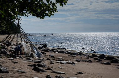 Robinson Crusoe ıssız bir adada bir gemi enkazından sonra deniz kenarındaki dallardan bir kulübe inşa eder..