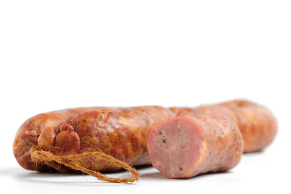 Köstliche Geräucherte Und Rohe Wurst Mit Rauch Auf Weißem Hintergrund — Stockfoto