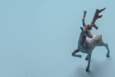 Mavi arka planda parlak ve parlak gümüş bir geyik, Noel ve yeni yıl tatili konsepti ve sembolü.