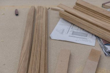 Bir meşe ağacı, arka planda aletler ve talaş olan bir marangozun atölyesine konulan malzemeleri engelliyor. Kereste hasadı. Kereste barının ayrıntıları. Örgü işi hobileri, ahşap işçiliği..