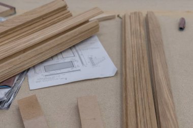 Bir meşe ağacı, arka planda aletler ve talaş olan bir marangozun atölyesine konulan malzemeleri engelliyor. Kereste hasadı. Kereste barının ayrıntıları. Örgü işi hobileri, ahşap işçiliği..