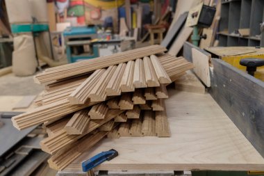 Bir meşe ağacı, arka planda aletler ve talaş olan bir marangozun atölyesine konulan malzemeleri engelliyor. Kereste hasadı. Kereste barının ayrıntıları. Örgü işi hobileri, ahşap işçiliği..