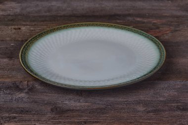 Koyu yeşil ve beyaz pastel. Güzel boş bir tabak. Koyu ahşap arka planda. yatay görüntü. Yan görünüm