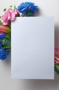 Mavi ve kırmızı karanfilli, güllü ve papatyalı renkli bir buket çiçekli beyaz davetiye. Dekorasyon. 5x7 oranı, A4, A5, A6 'ya benziyor..