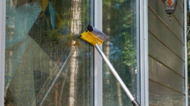 Paspaslı bir el büyük bir pencereyi siler.
