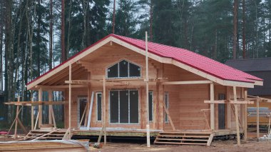 Yeşil bir alanda kütük ve kerestelerden yapılmış bir kır evi inşa etmek. Doğal ahşaptan yapılmış samimi çevre dostu bir ev, aile tatili için bir bungalov.