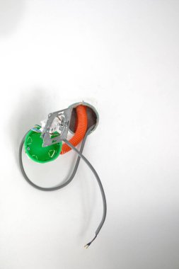 Beyaz alçı duvar, doku ve elektrik prizleri. Elektrik kabloları dışarı çıkıyor, yalıtım ile korunmuyor, elektrik şoku tehlikesi, kopyalama alanı