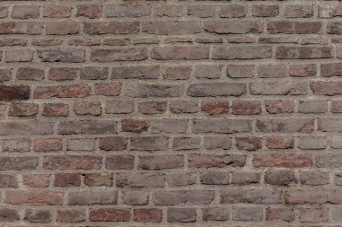seçici odak, eskimiş eski koyu kahverengi ve kırmızı tuğla duvar arka planı, paslı taş teknolojisi blokları, yumuşak odak.