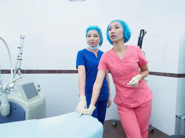 Due giovani donne asiatiche medici in cabounet laser di ospedale — Foto Stock