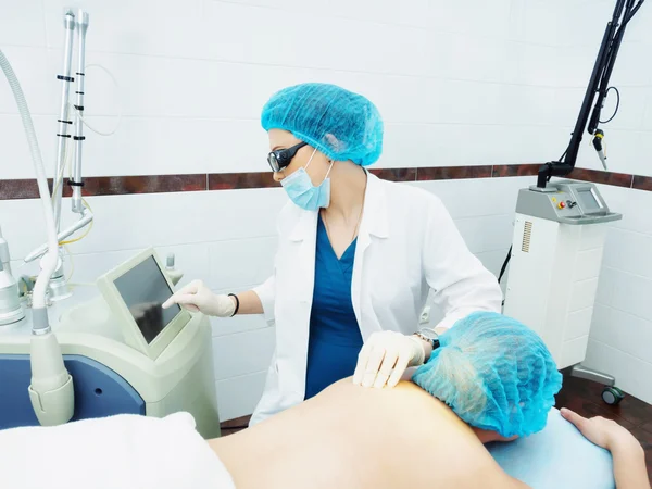 Tratamiento láser. Médico caucásico haciendo procedimiento extracción de nevo de piel a paciente mujer — Foto de Stock