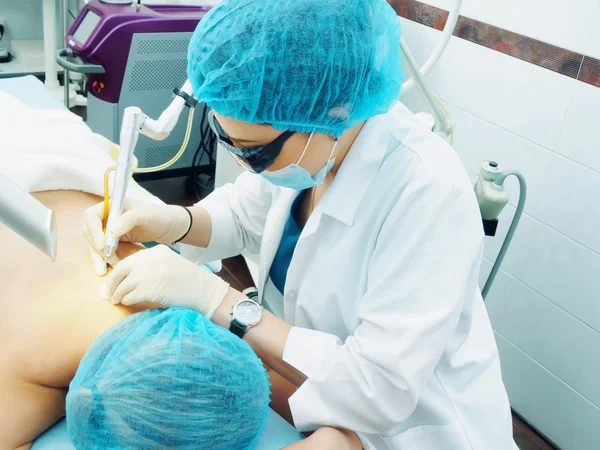 Trattamento laser. Medico caucasico rendendo procedura rimozione della pelle nevo alla paziente donna — Foto Stock