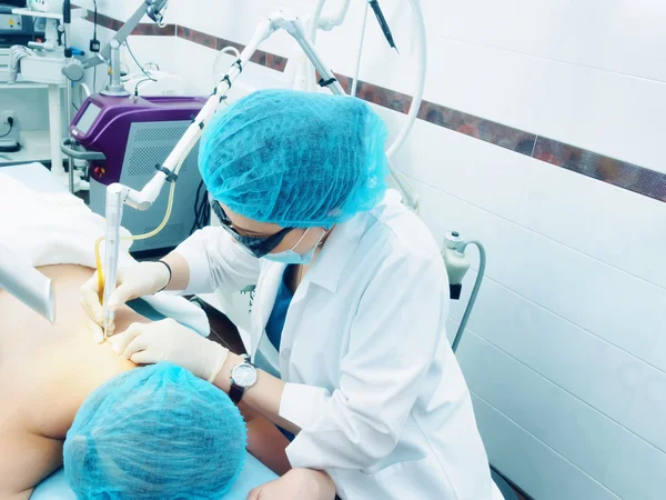 Trattamento laser. Medico caucasico rendendo procedura rimozione della pelle nevo alla paziente donna — Foto Stock