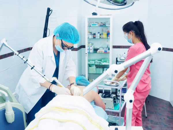 Tratamiento láser. Médico caucásico haciendo procedimiento extracción de nevo de piel a paciente mujer — Foto de Stock