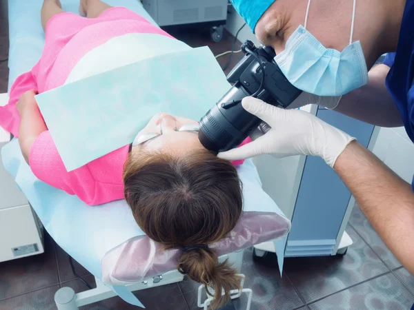 Médico joven usando dermatoscopio en paciente asiática antes de que la piel del laser resurfacing en medicina estética . — Foto de Stock