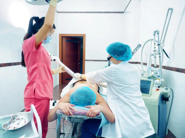 Laserbehandlung. Kaukasischer Arzt macht Eingriff Hautnävus Entfernung an Frau Patientin Stockfoto