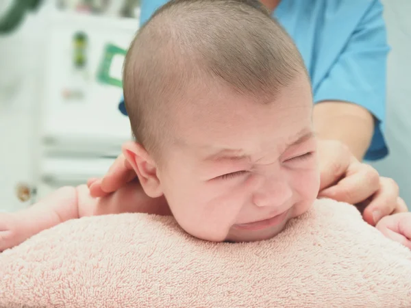 Médico massagem pequeno branco chorando bebê de volta — Fotografia de Stock