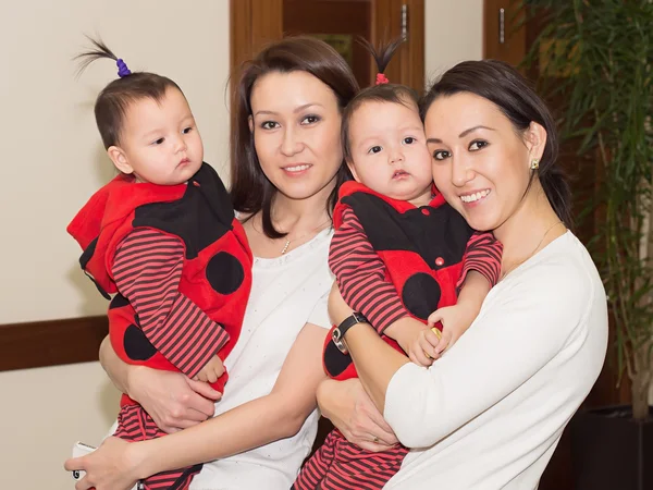 Asian girls sisters twins with their children baby at celebration — Stock Photo, Image