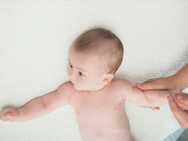 Arzt massiert kleine kaukasische Babyhand Stockfoto
