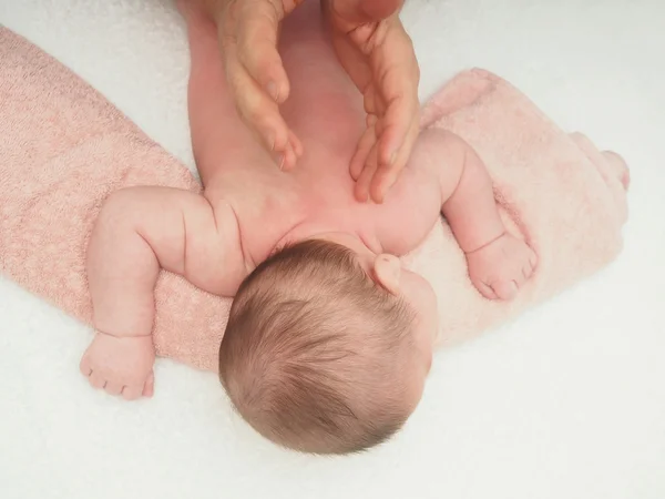 Arzt massiert kleine kaukasische Baby zurück Stockbild