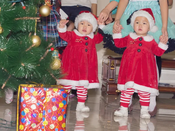Asiatiska barn baby flickor tvillingar tillsammans vid firande julen Royaltyfria Stockfoton