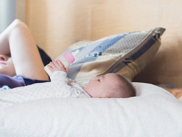 Bambino che beve latte dalla bottiglia a casa — Foto Stock