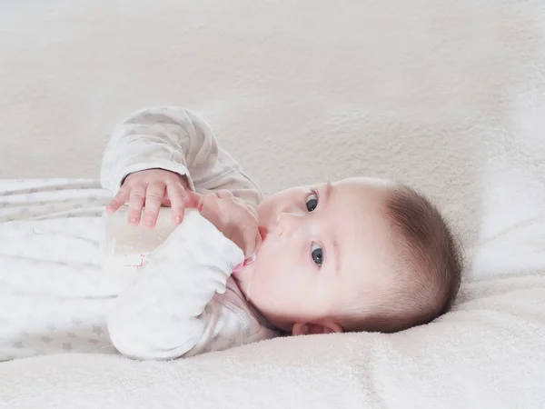 Baby boy dricka mjölk från flaskan hemma — Stockfoto