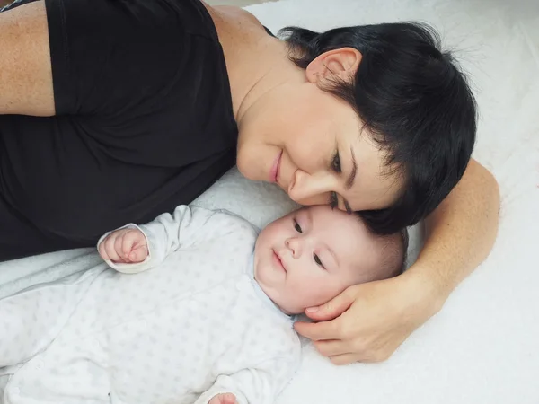 Feliz família caucasiana deitada na cama em casa — Fotografia de Stock