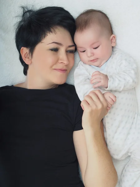 Feliz família caucasiana deitada na cama em casa — Fotografia de Stock