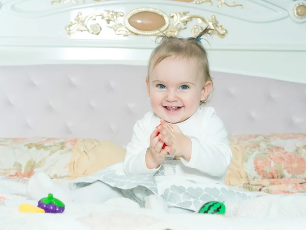 Small caucasian child girl play with toys on the bed at home — Stock Photo, Image