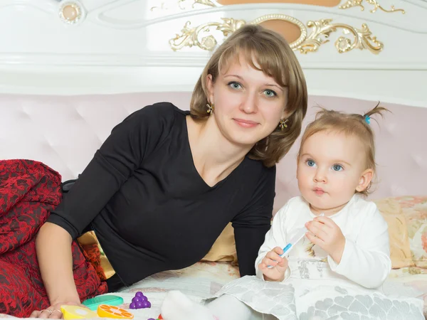 Glückliche kaukasische Familie Mutter und Tochter auf dem Bett zu Hause — Stockfoto