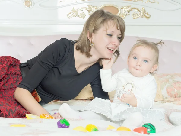 Glückliche kaukasische Familie Mutter und Tochter auf dem Bett zu Hause — Stockfoto