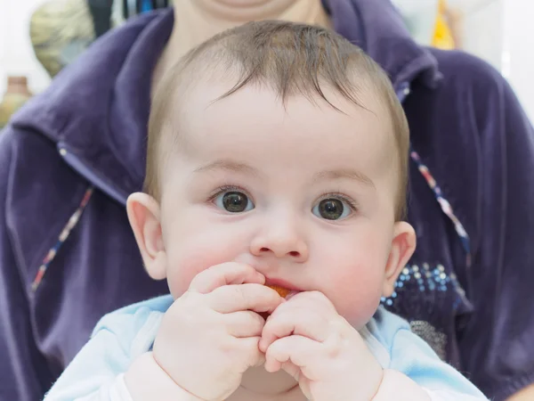 Little caucasian baby boy eating dried apricot — Stock Photo, Image