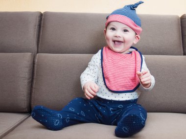 Evde koltukta oturan beyaz bebek çocuk renksizdir önlük