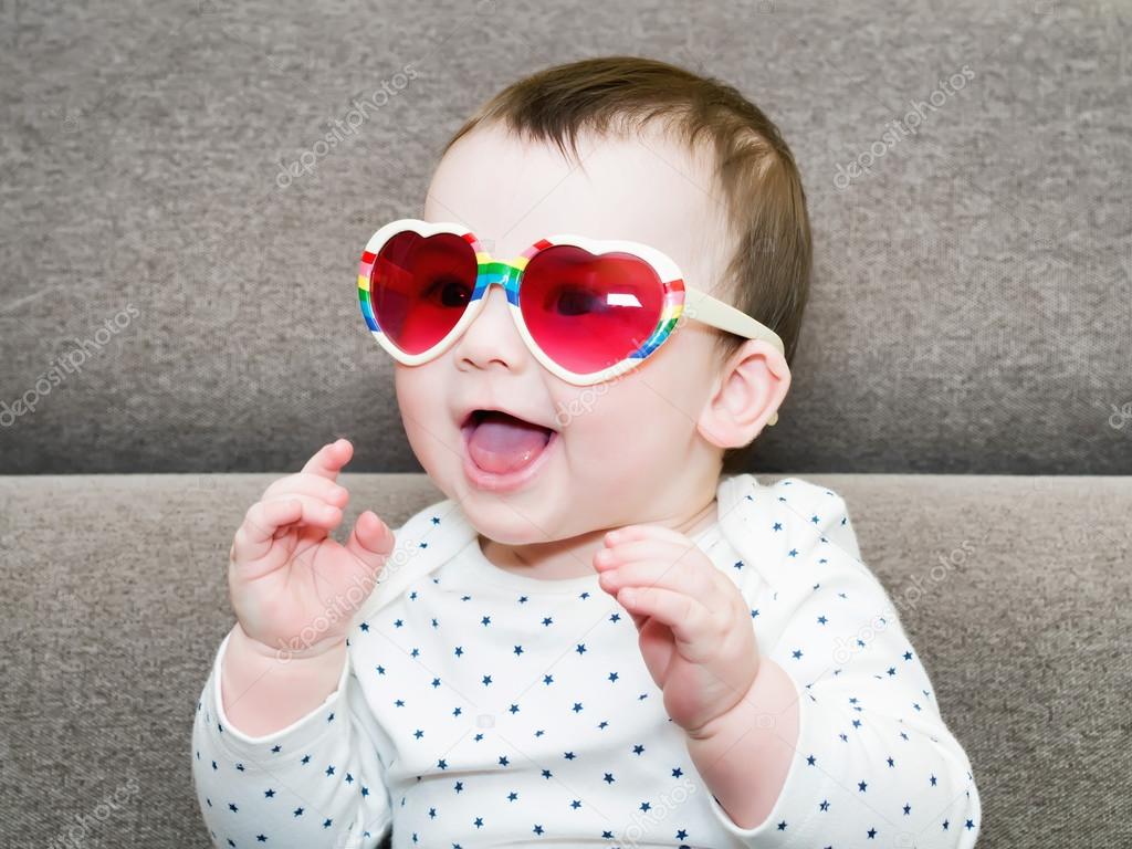 Caucasian baby boy weared glasses  sitting on sofa at home