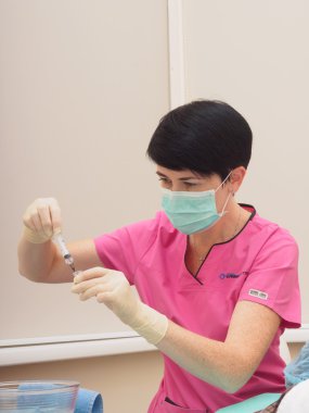 Medical doctor with syringe preparing to make injection
