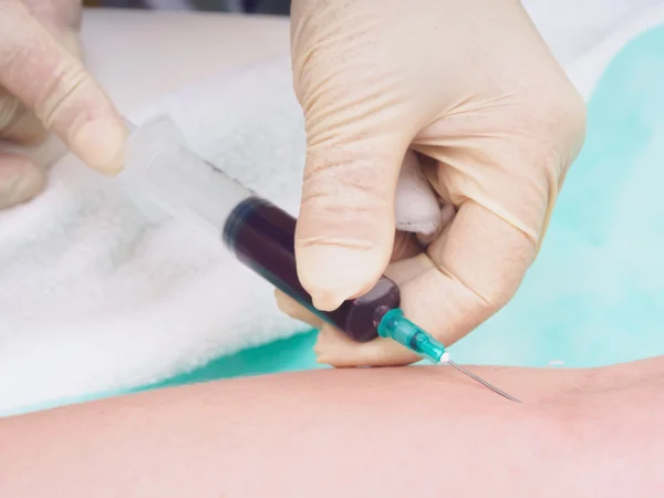 Médico que tira sangue do braço do paciente feminino para exame — Fotografia de Stock